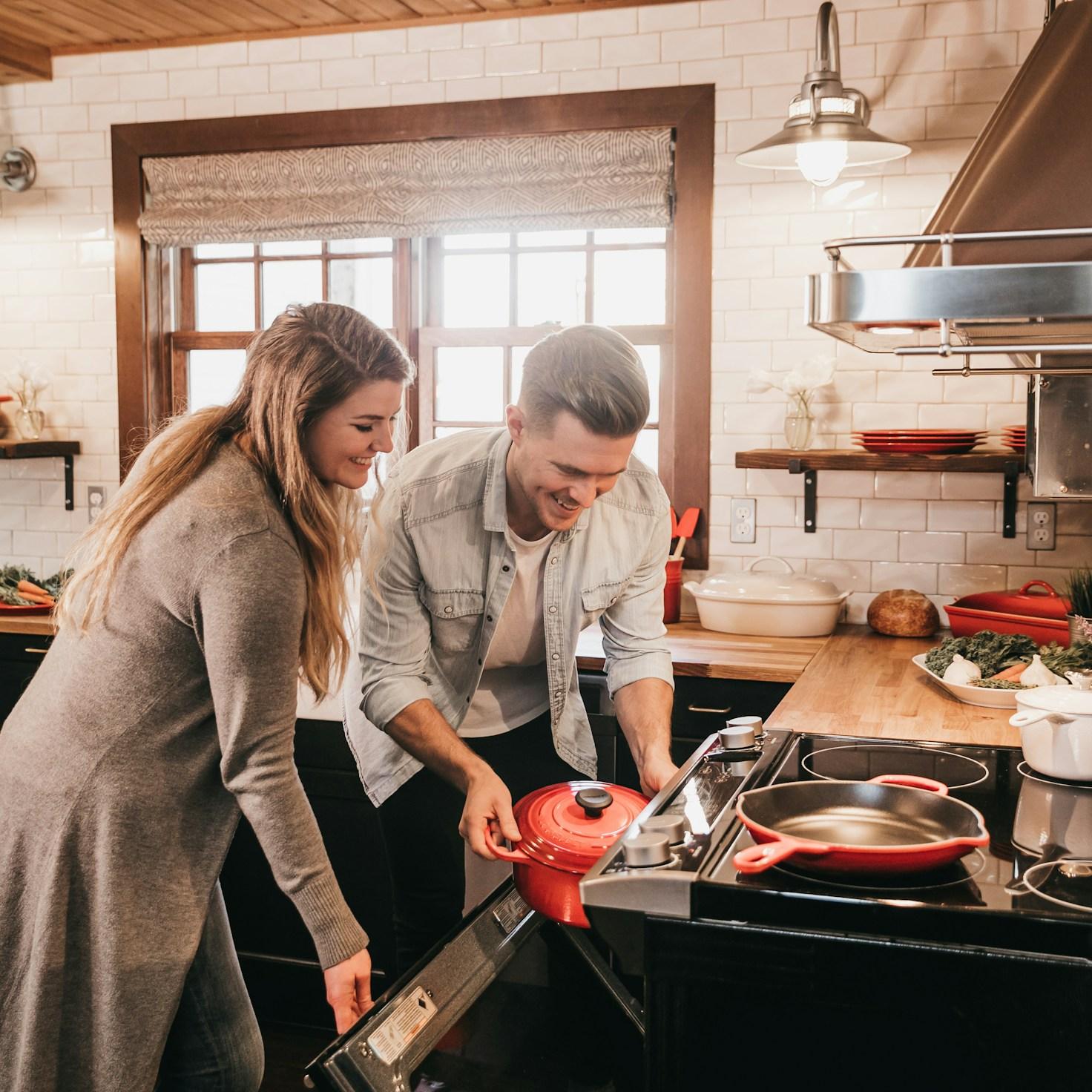 People collaborating in a modern kitchen, exchanging recipes and techniques
